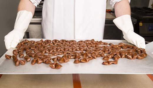 Worker holding a tray of chocolates
